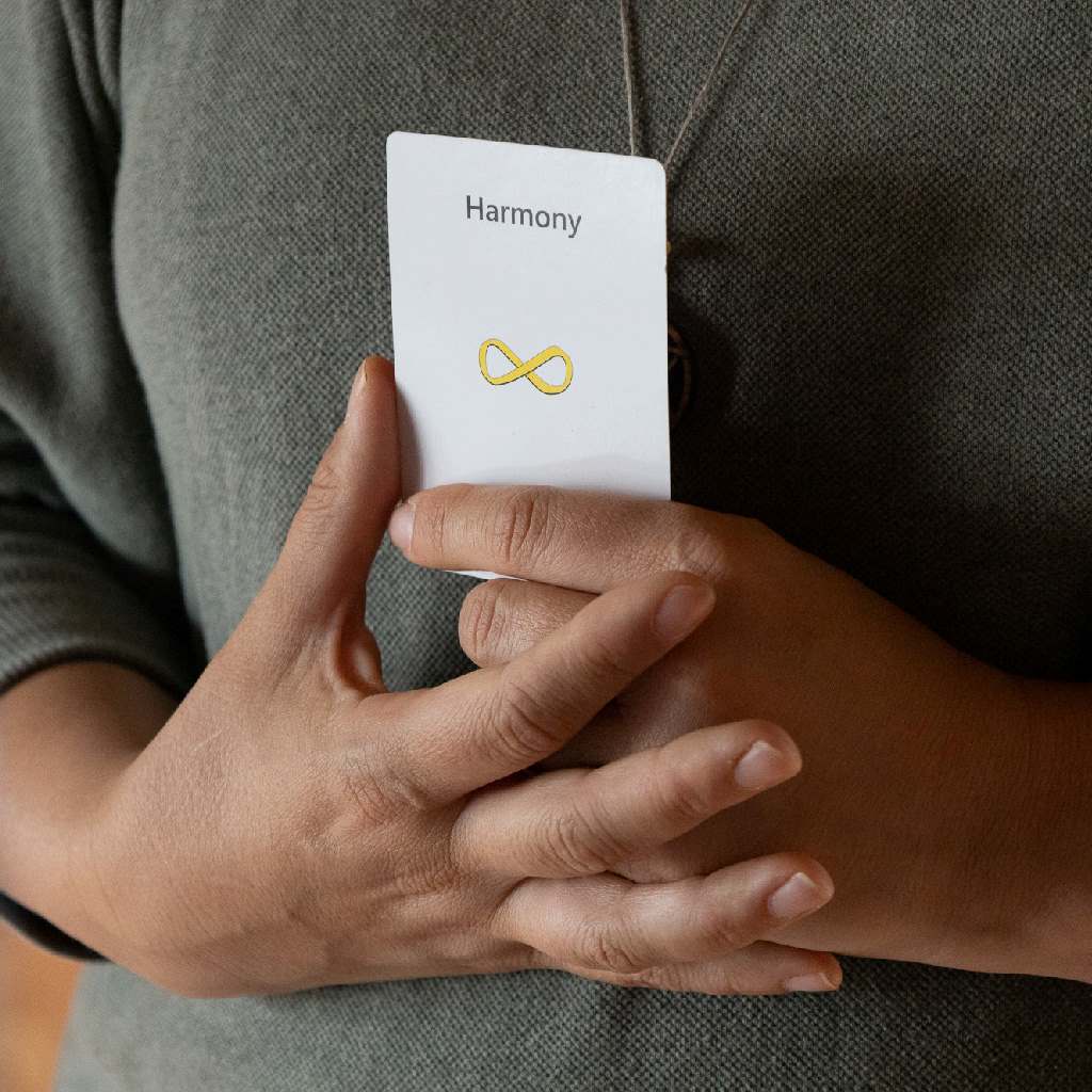 A participant holding a "Harmony" needs card, image 10 of 13